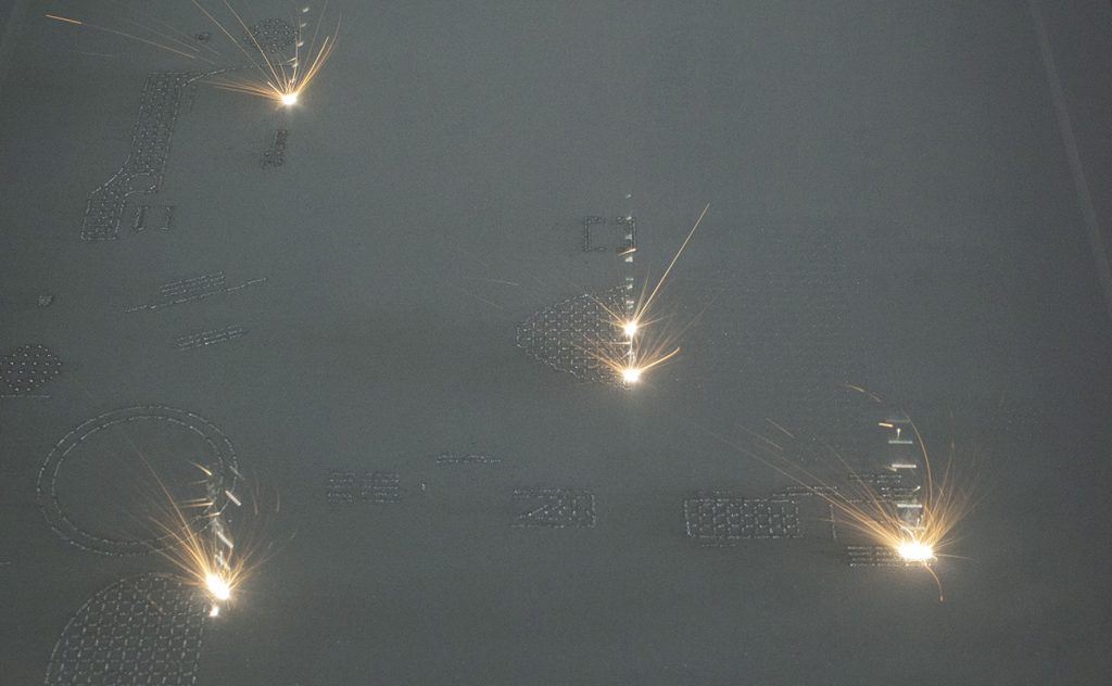 Fig. 5 A set of lugs being built on a RenAM 500Q four-laser PBF-LB system. (Courtesy Renishaw PLC)