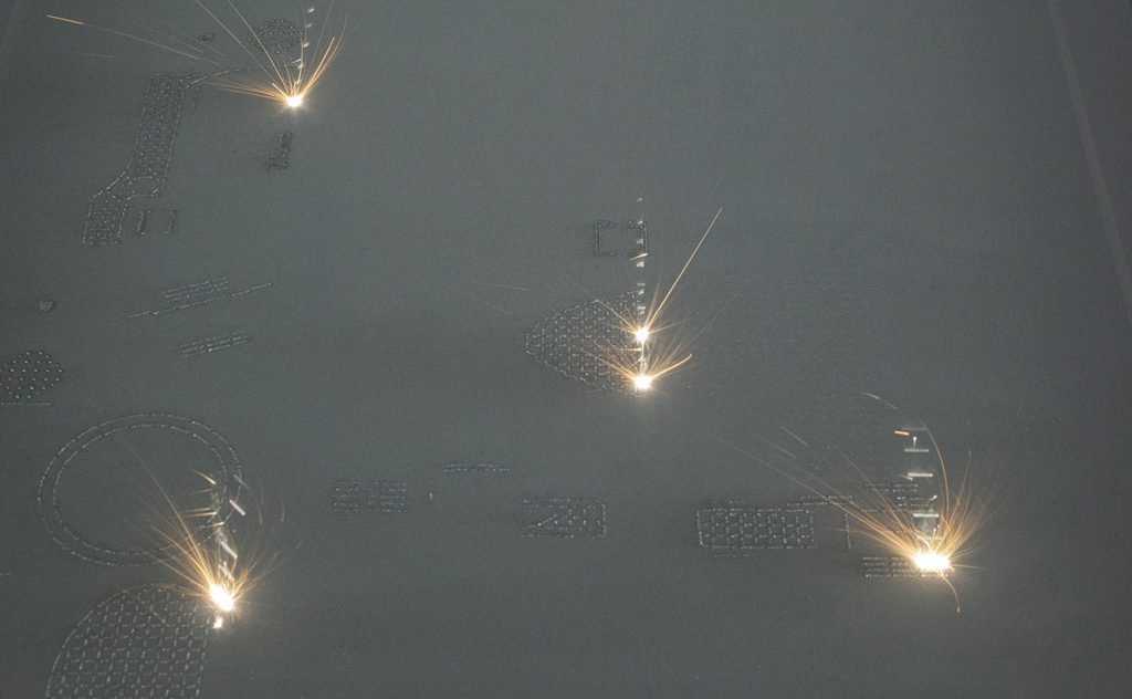 Fig. 5 A set of lugs being built on a RenAM 500Q four-laser PBF-LB system. (Courtesy Renishaw PLC) 