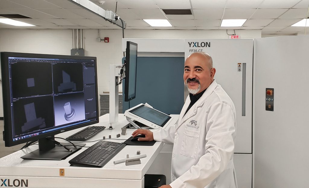 Fig. 1 Ayman Salem, PhD, founder of MRL, shown with the company's Yxlon FF35 CT high-resolution Computed Tomography system, used for non-destructive testing of additively manufactured materials 
