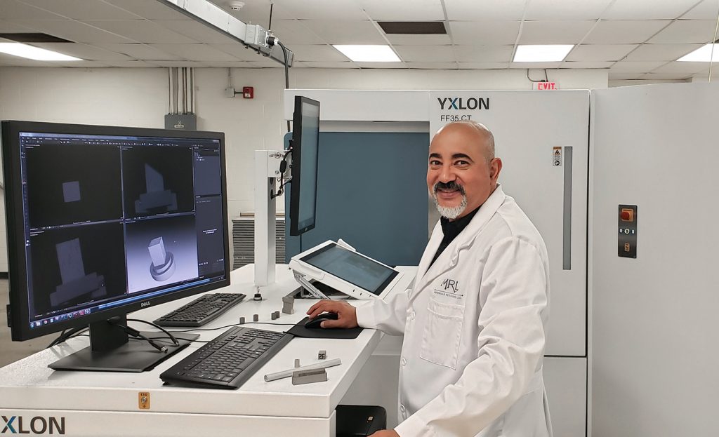 Fig. 1 Ayman Salem, PhD, founder of MRL, shown with the company's Yxlon FF35 CT high-resolution Computed Tomography system, used for non-destructive testing of additively manufactured materials
