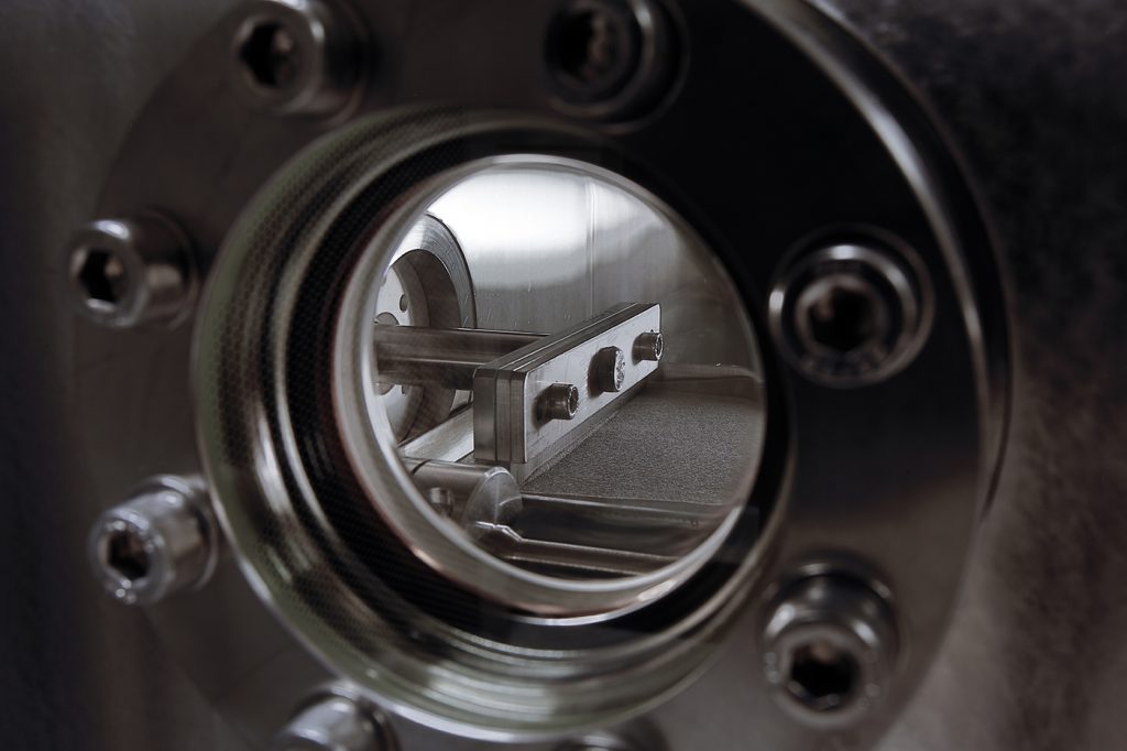 Fig. 7 A view into the build chamber of Freemelt's Freemelt ONE PBF-EB machine, showing the powder spreading process (Courtesy Freemelt AB)