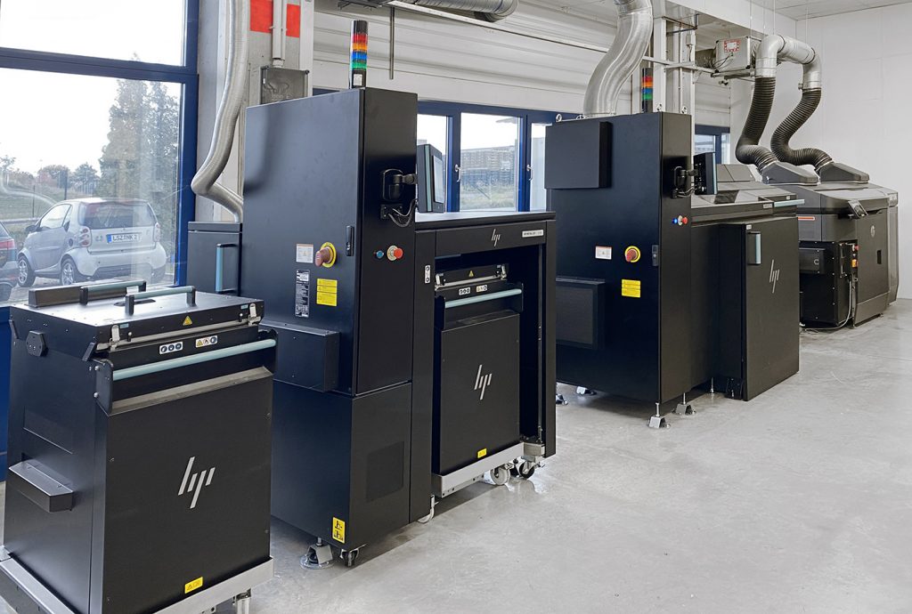 Fig. 2 HP's Metal Jet solution installed at GKN Additive. This image shows, from left to right: build unit, curing station, and printers (Courtesy GKN PM)