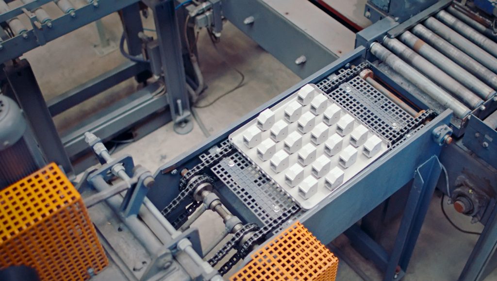 Fig. 6 A view of a sintering tray loaded with metal BJT filters being conveyed through a continuous sintering furnace system (Courtesy GKN PM)