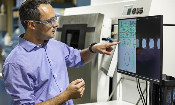 ORNL researcher Zackary Snow compares data from different types of images collected during and after metal parts were additively manufactured (Courtesy Carlos Jones/ORNL, US Dept. of Energy)