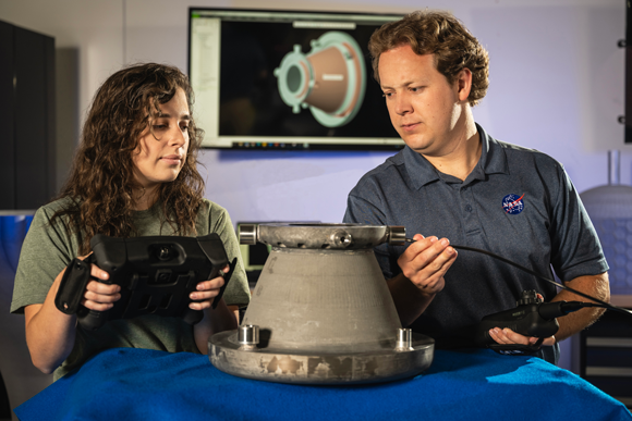 NASA Engineers, Tessa Fedotowsky and Ben Williams, from Marshall Space Flight Center in Huntsville, Alabama, inspect the RAMFIRE nozzle following successful hot-fire testing (Courtesy NASA)