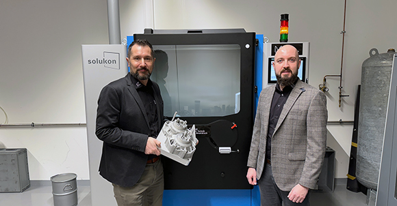 M&H CEO Patrick Herzig with Philipp Schwemberger, Head of Additive Manufacturing, in front of the new SFM-AT1000-SM&H depowdering system at the company’s headquarters in Austria (Courtesy Solukon)