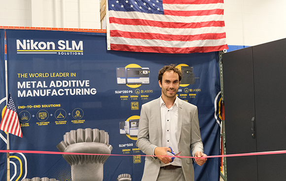 Andre Thiemann, Vice President of Production for Nikon SLM Solutions, celebrates the start of US production of the company’s NXG XII 600 metal Additive Manufacturing machine (Courtesy Nikon SLM Solutions)