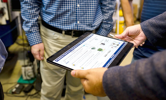 Dr Mohsen Taheri Andani showing a test sample that was completed based on the Predictive Real-Time Intelligence for Metallic Endurance (Courtesy Texas A&M)