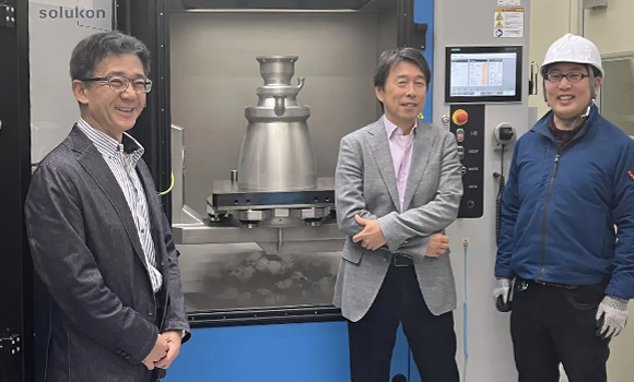 From left: Hiroyuki Nagasaka, Assistant General Manager Advanced Manufacturing Business Unit; Yuichi Shibazaki, General Manager Advanced Manufacturing Business Unit and Director & Co-President & Co-CEO of Nikon Advanced Manufacturing Inc, Officer in charge of Riblet Solution Development Department; and Yuki Furuya, Staff, Advanced Engineering Section, Business Planning Department Advanced Manufacturing Business Unit, in front of the depowdering SFM-AT1000-S at NAMTC Japan (Courtesy Solukon)