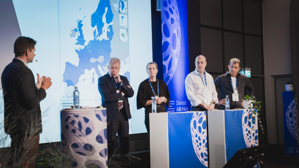 Fig. 7 Panel discussion: Prepare your factory for defence. From left to right: Frank Rosengreen Lorenzen, CEO, Danish AM Hub (moderator), Poul Skadhede, Chairman, Odense Maritime Technology, Anne Angaard, Chief of Staff, Chora A/S, Anders Puck Nielsen, Officer and Military Analyst, Royal Danish Defence College, and Nicholas Hawtin, Startup Specialist, Defence Tech Denmark (Courtesy Danish AM Hub)