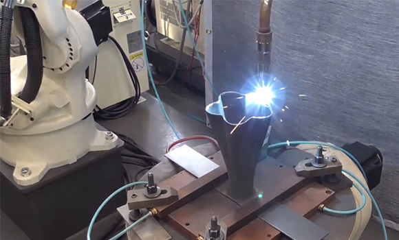 The robotic arm depositing material during a build (Courtesy Daihen)