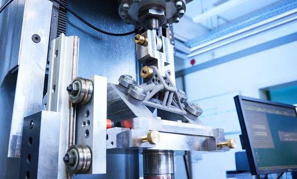 Cyclic load testing of an additively manufactured metal component after mechanical surface treatment at the highly stressed zones. In the experiment, the increase in service life achieved by the post-treatment is tested (Courtesy Fraunhofer IWM/Kai Wudtke)
