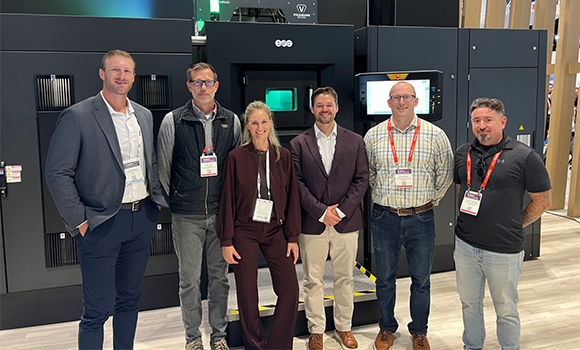 Representatives from Evology Manufacturing and EOS at IMTS 2026, where the companies agreed the purchase of an EOS M 400-4 metal Additive Manufacturing machine (Courtesy EOS)