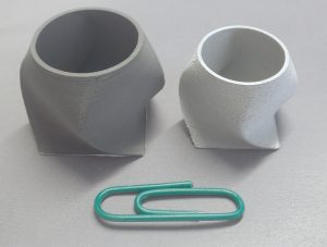 Fig. 19 A twisted box in the as-printed and as-sintered condition shows the capabilities of the FFF process when using a metal feedstock [3]