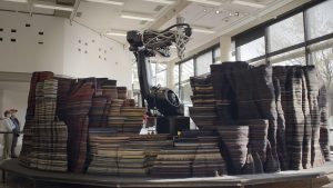 Fig. 8 Sker, an additively manufactured sculpture designed by the artist Peter Lang, installed at the Sprengel Museum in Hannover, Germany, depicts the formation of an oceanic island by an Icelandic lava flow and measures 7.5 m in diameter and 2 m high. The sculpture was produced by Additive Techtonics, a subsidiary of FIT AG, using a novel AM process and a granular biopolymer made from lignin (Courtesy FIT AG)