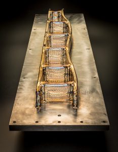 Fig. 3 A 1.2 m long Ti-6Al-4V wing spar demonstrator, built at Cranfield University for BAE Systems in 2012, in the as-built condition. It demonstrated successful control of distortion and the possibility to deposit large components back-to-back, however it also highlighted the requirement for better thermal compensation strategies to control the layer height in critical areas (Courtesy Cranfield University and BAE Systems)