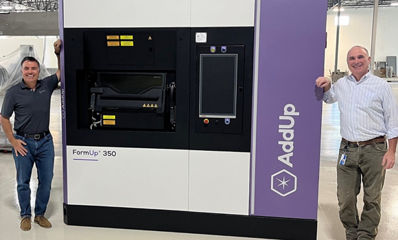 Rush LaSelle, CEO of AddUp (left) and Greg Morris, CTO of Zeda (right) with the first of eight new FormUp350 AM machines at Zeda’s new facility (Courtesy Addup)
