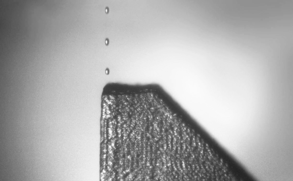 An in-process image showing the release of multiple droplets of molten material (Courtesy Xerox)