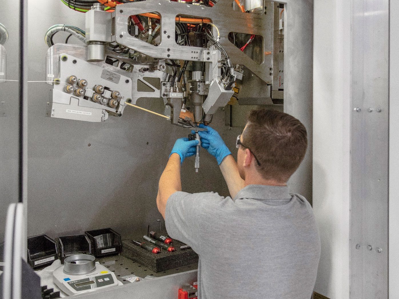 Fig. 5 Changing a consumable in a Merke IV machine. The three PBF-LB components used in the deposition system are clearly visible (Courtesy Norsk Titanium)