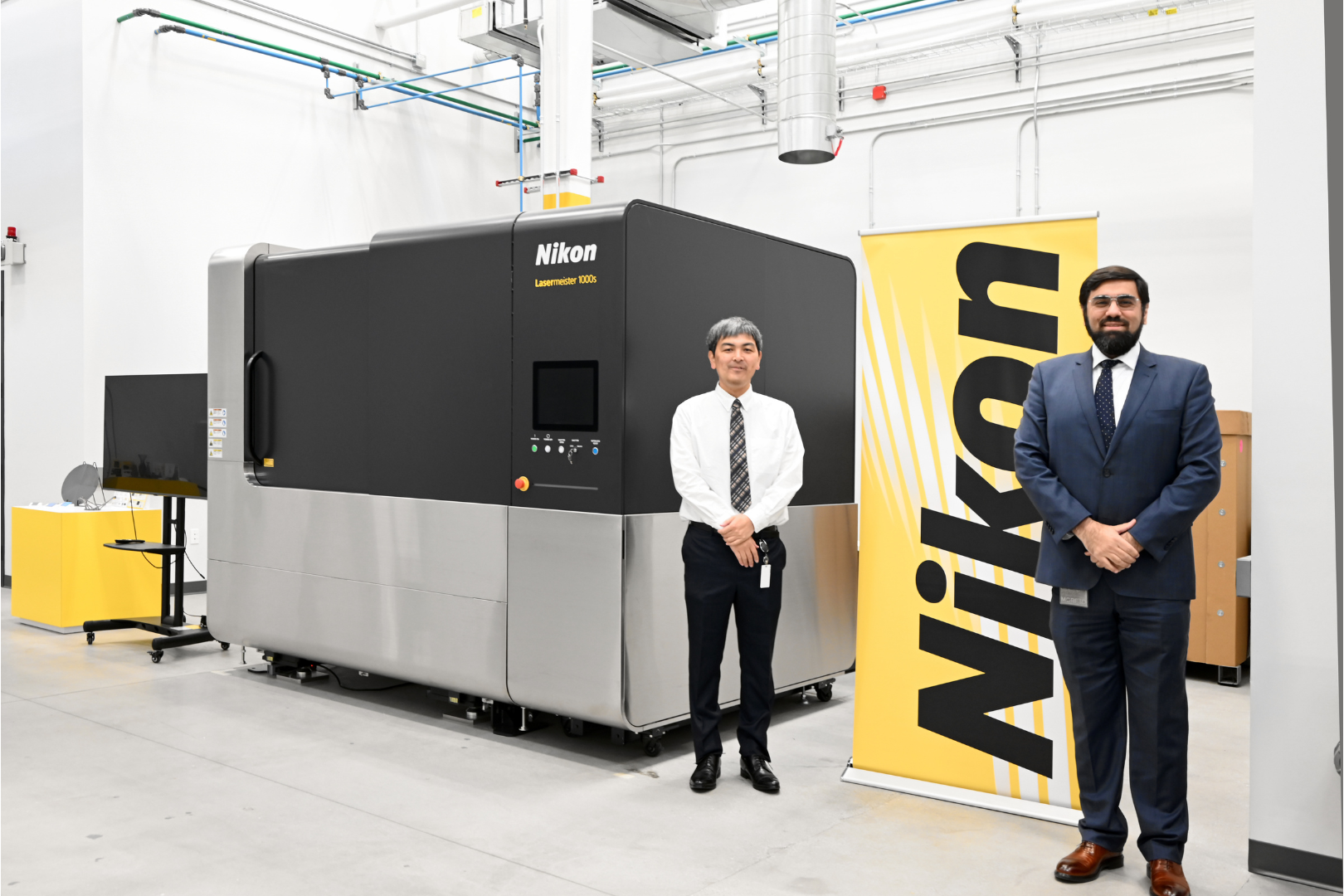 Fig. 11 Koki Takeshita with Behrang Poorganji (Vice President of Technology at Nikon Advanced Manufacturing) in front of a Lasermeister 1000s DED machine (Courtesy Nikon) 